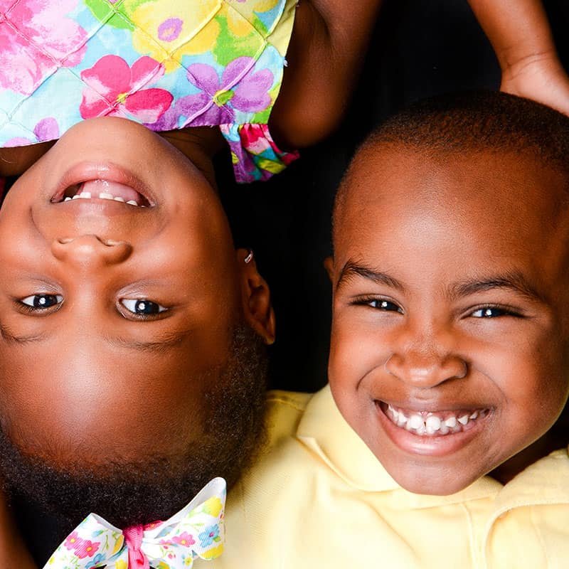 Siblings with heads together looking up and laughing